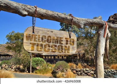 old wood signboard with text " welcome to Tucson" hanging on a branch