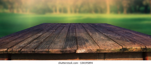 Old Wood Table In Field With Green Blur Background Use For Outdoor Background