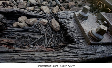 The Old Wood Texture Of The Broken Railroad Tracks And The Two Old Bolts