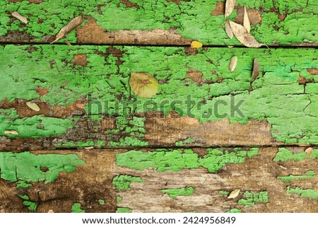Old wooden background texture of boards with cracked green paint. table. Autumn yellow brown fallen leaves on shabby grunge wood panels, frame, flat lay
