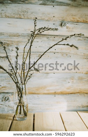 Old wooden background with willow  branches in a bottle 