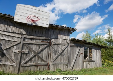 Old wooden barn with a basketball hoop attached.