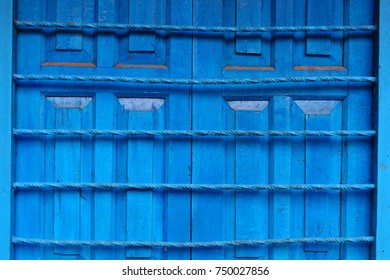 Old wooden blue painted window shutters of indian traditional house with window gratings as wooden blue background.