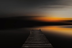 Old Wooden Boardwalk, Dock In Lake With Abstract Blurred Background In Dark Evening. Abstract Blurred Sunset Background.