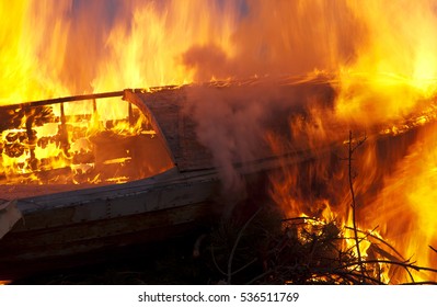 Old wooden boat on fire with high flames