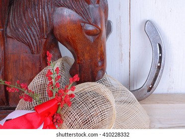 An Old, Wooden Bookend Of A Horse's Head With A Straw Hat And A Horse Shoe On Wooden Background. Great For Kentucky Derby Or Any Horse Race