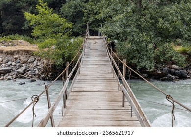 Old wooden bridge in the mountains through the strong mountain river - Powered by Shutterstock