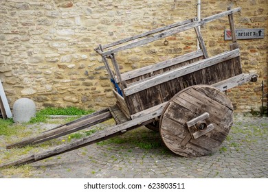 Old Wooden Cart With A Stone Masonry Wall On The Background With A 