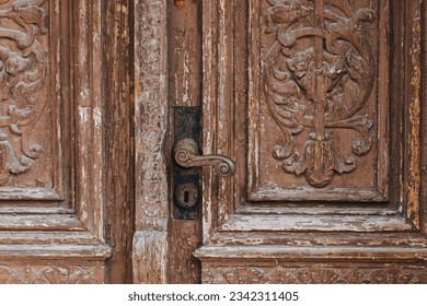 old wooden and carved door with paint peeling off 