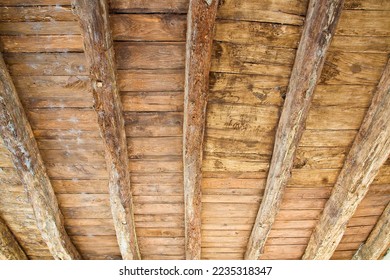 Old wooden ceiling with raw wooden beams and planks