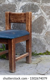 An Old Wooden Chair With A Torn Leather Seat.