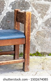 An Old Wooden Chair With A Torn Leather Seat.