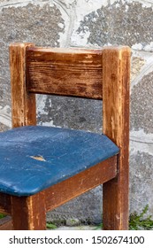 An Old Wooden Chair With A Torn Leather Seat.