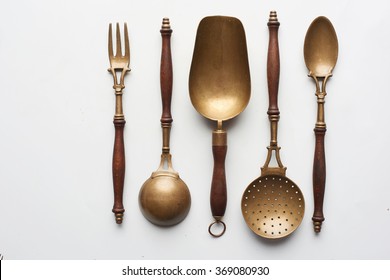 old, wooden, copper, vintage cutlery fork, spoon, scoop, skimmer kitchenware set close up studio shot.