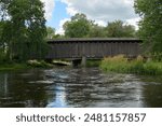 An old wooden covered bridge and river in the summer in Cedarburg