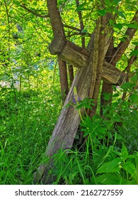 Old Wooden Cross In The Cemetery Leaned