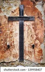 Old Wooden Cross On A Grunge Crumbling Wall