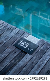 Old Wooden Decking Pool Side With Dark Stone Signage Have A Relax Turquoise Color Of Water