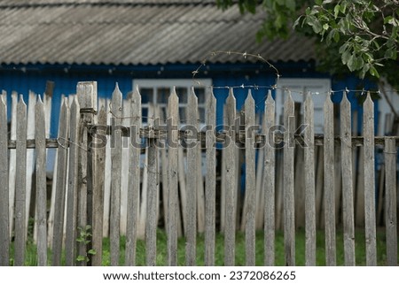 Old wooden door in a blue painted house in the village on a summer day. 