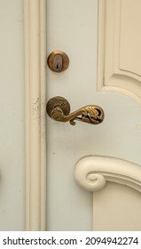 An Old Wooden Door With A Brass Doorknob.