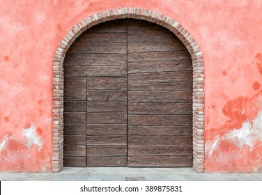 Old wooden door with brick arch.