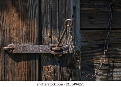 Old wooden door closed with an old rusty padlock. High quality photo