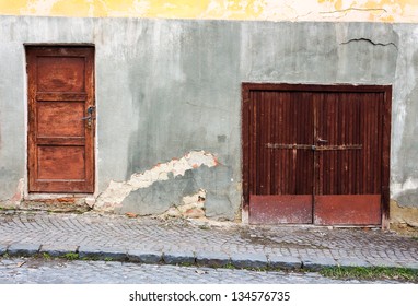 Old Wooden Door With Lock Granary In A Metal Frame On The Old Cracked Wall