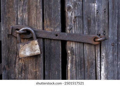 old wooden door locked with rusty padlock. vintage gate to building locked with bolt. - Powered by Shutterstock