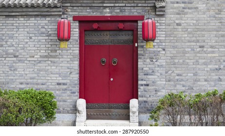 Old Wooden Door In Red Wall. Typical China Architecture