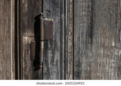 Old wooden door with rusted hinge. 