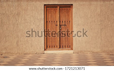 old wooden door in a stone wall, Arabic style construction                             