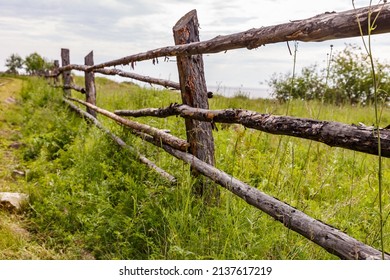 Old wooden fence on green meadow. Rustic pole fence - Powered by Shutterstock