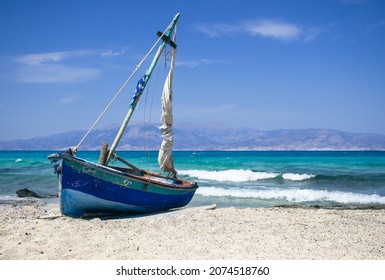 Old wooden fishing boat on deserted beach, turquoise sea in the background. Chrissy beach, Crete.