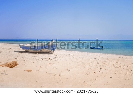 old wooden fishing boats resting on the beach of the bay blue lagoon in egypt