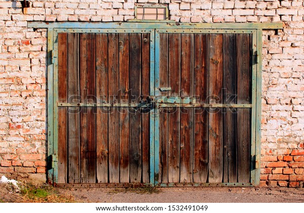 Old wooden garage doors. Flaking paint and\
rust on gates of abandoned building.\
