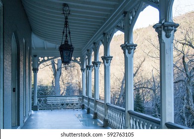 Old Wooden Home Porch With Railings, Columns, And Hanging Pendant Light Fixture In Pennsylvania 