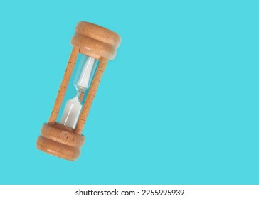Old wooden hourglass isolated on Cyan background. - Shutterstock ID 2255995939