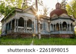 Old wooden house. Retro architecture. Facade. Village vintage. Abanoned blue house with carved windows. A large log cabin. Old, abandoned blue prairie farmhouse with trees and green grass