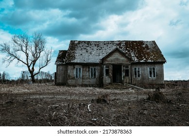 Old wooden house,dramatic clouds at night. Abandoned Haunted Horror House.Near is one tree at night.Toned. - Shutterstock ID 2173878363