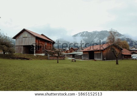 Old wooden houses in a farm behind snow mountain in Europe