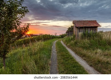 old wooden hut in countryside at sunset