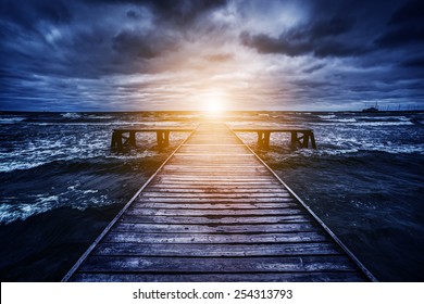 Old Wooden Jetty During Storm On The Ocean. Abstract Light At The End. Concept Of Hope, Future, Religion, God Etc.