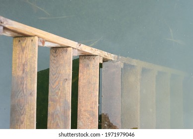 Old Wooden Ladder In The Water Close Up