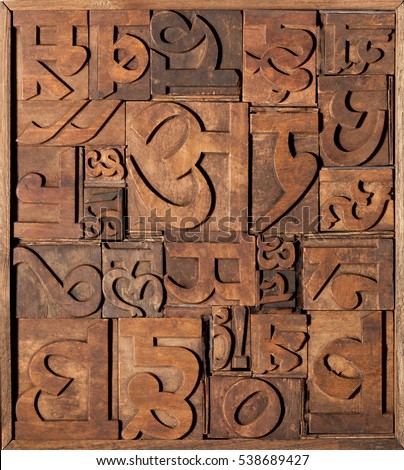 Old wooden letterpress blocks for Indian language. Collage made with various Hindi letter characters. 
