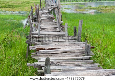 Old wooden  long  bridge cross the lake.