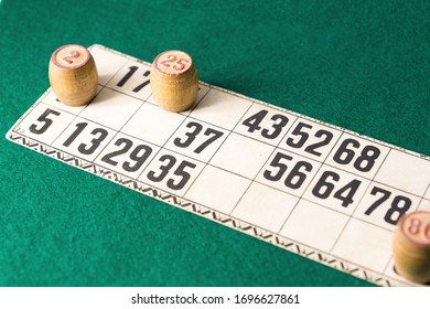 Old Wooden Lotto Barrels And Playing Cards Isolated On Green Background.