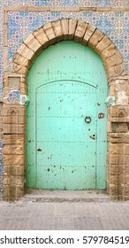 Old wooden Moroccan door with a faded blue green color, Essaouira, Morocco