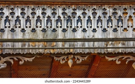 Old wooden ornamented design of balcony in small village in Switzerland Alps