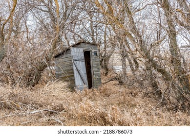 Old wooden outhouse in the bush on the prairie countryside in Saskatchewan, Canada
