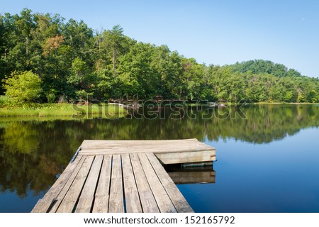 Old wooden pier on small country lake.